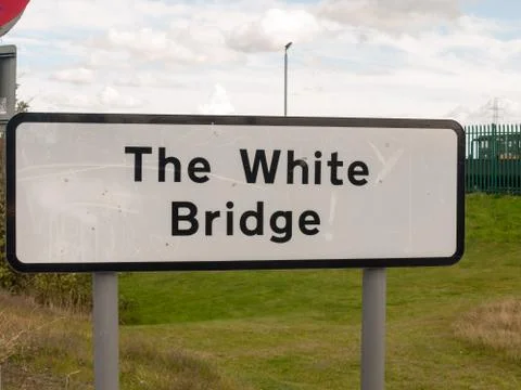 Big rectangular black and white road sign the white bridge location 스톡 사진