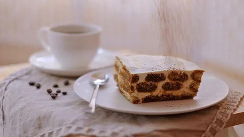The big rectangular piece of tiramisu falls down cocoa.Slow-motion Stock Footage 89975442