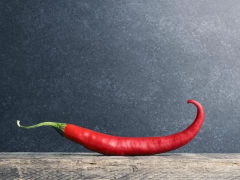 Big red chili pepper on a rustic wooden kitchen table Stock Photos