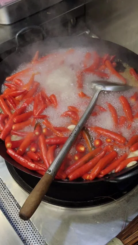 Big red chillies being boiled in a black coloured saucepan 스톡 동영상 218099449