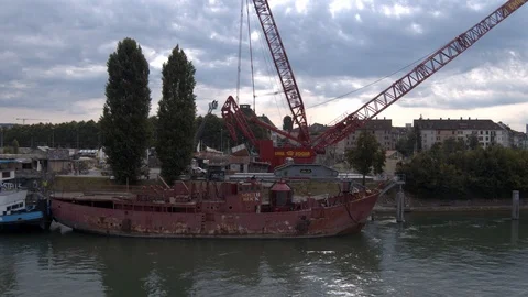 A big red crane preparing an old ship for repairs at the shipyard Video stock 120986566