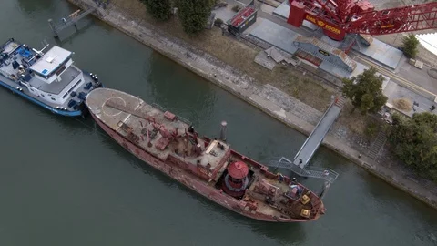 A big red crane preparing an old ship for repairs at the shipyard Stock Footage 120986605