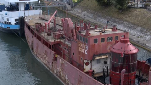 A big red crane preparing an old ship for repairs at the shipyard Stock Footage 120986794