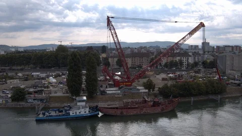 A big red crane preparing an old ship for repairs at the shipyard Stock Footage 120986957