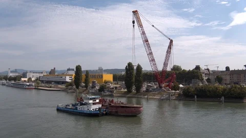 A big red crane preparing an old ship for repairs at the shipyard Stock Footage 120987442