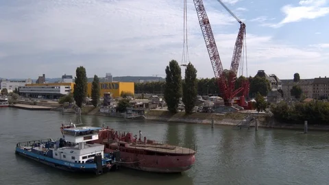 A big red crane preparing an old ship for repairs at the shipyard Stock Footage 120987529