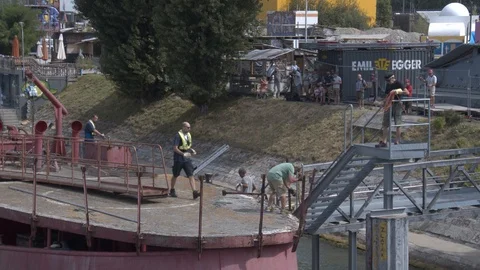 A big red crane preparing an old ship for repairs at the shipyard Stock Footage 120987625