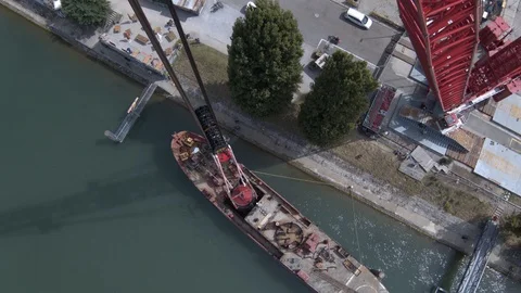 A big red crane preparing an old ship for repairs at the shipyard Stock Footage 120987901