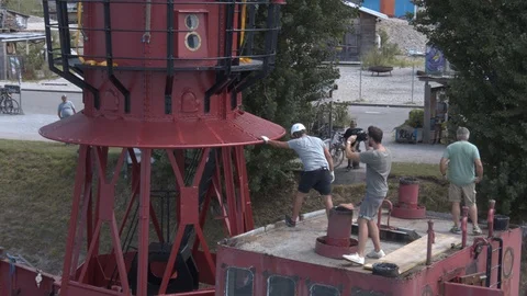 A big red crane preparing an old ship for repairs at the shipyard Stock Footage 120988194