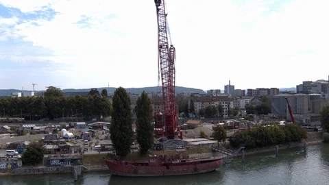 A big red crane preparing an old ship for repairs at the shipyard Stock Footage 120988345