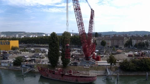 A big red crane preparing an old ship for repairs at the shipyard Stock Footage 120988546