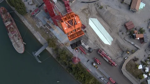 A big red crane preparing an old ship for repairs at the shipyard Stock Footage 120989191