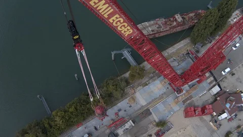 A big red crane preparing an old ship for repairs at the shipyard Video stock 120989250
