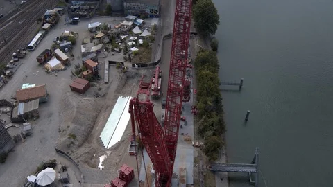 A big red crane preparing an old ship for repairs at the shipyard Stock Footage 120989325