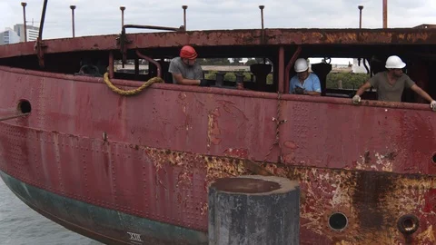 A big red crane preparing an old ship for repairs at the shipyard Video stock 120989561