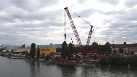 A big red crane preparing an old ship for repairs at the shipyard Stock Footage 120989663