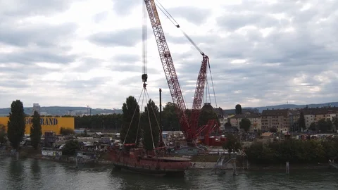A big red crane preparing an old ship for repairs at the shipyard Stock Footage 120989809