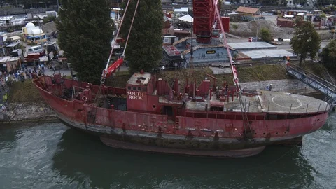 A big red crane preparing an old ship for repairs at the shipyard 스톡 동영상 120989922