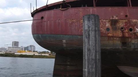 A big red crane preparing an old ship for repairs at the shipyard Stock Footage 120990002