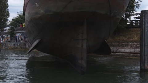 A big red crane preparing an old ship for repairs at the shipyard Stock Footage 120990780