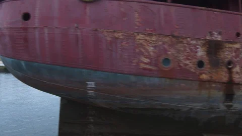 A big red crane preparing an old ship for repairs at the shipyard Stock Footage 120990836