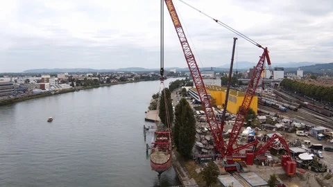 A big red crane preparing an old ship for repairs at the shipyard Stock Footage 120991108