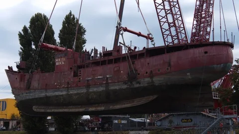 A big red crane preparing an old ship for repairs at the shipyard Video stock 120991526