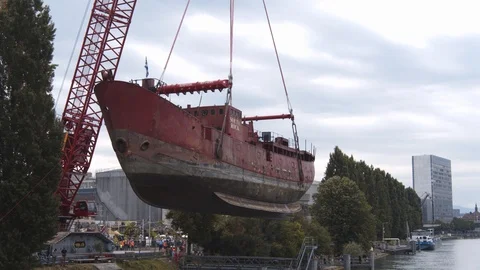A big red crane preparing an old ship for repairs at the shipyard Video stock 120991643