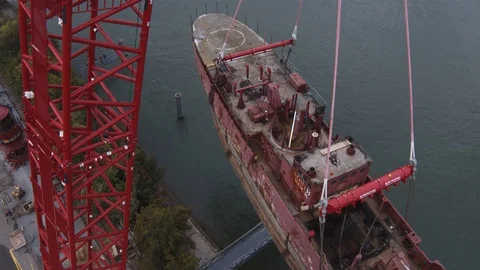 A big red crane preparing an old ship for repairs at the shipyard Stock Footage 120992212