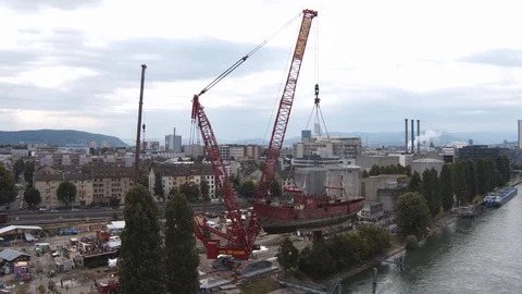 A big red crane preparing an old ship for repairs at the shipyard Stock Footage 120992496