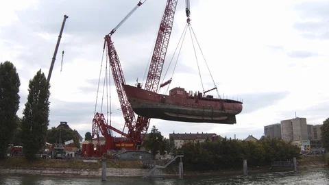 A big red crane preparing an old ship for repairs at the shipyard Video stock 120992693