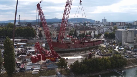 A big red crane preparing an old ship for repairs at the shipyard Stock Footage 120992799