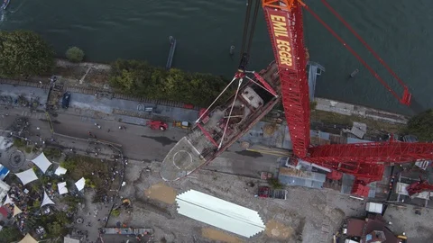 A big red crane preparing an old ship for repairs at the shipyard Stock Footage 120992957