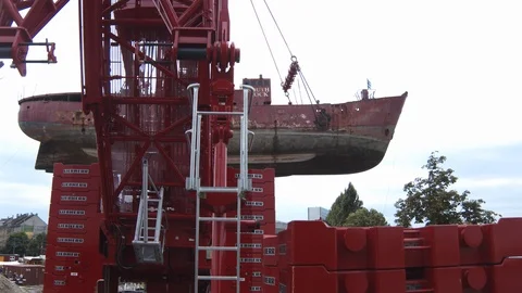 A big red crane preparing an old ship for repairs at the shipyard Video stock 120993114