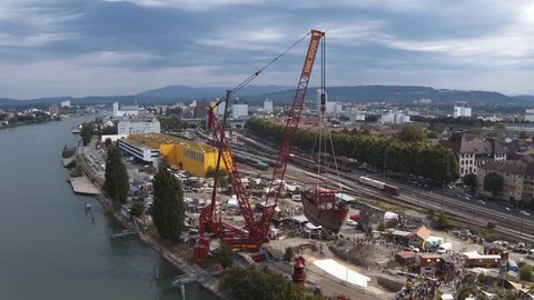 A big red crane preparing an old ship for repairs at the shipyard Stock Footage 120993235