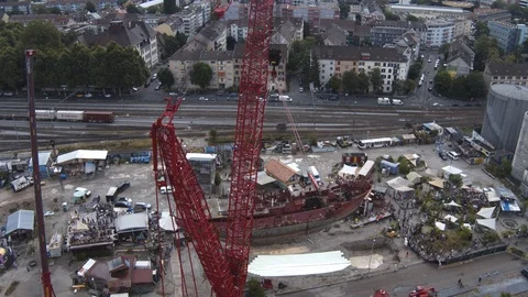 A big red crane preparing an old ship for repairs at the shipyard Stock Footage 120993277