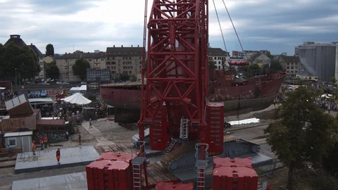A big red crane preparing an old ship for repairs at the shipyard Stock Footage 120993606