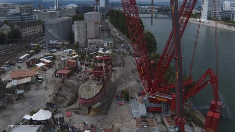 A big red crane preparing an old ship for repairs at the shipyard Stock Footage 120993707