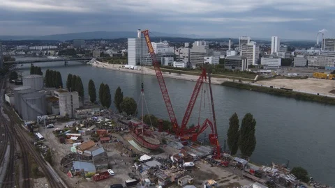 A big red crane preparing an old ship for repairs at the shipyard Stock Footage 120993859