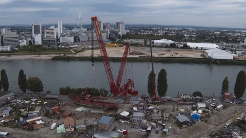 A big red crane preparing an old ship for repairs at the shipyard Stock Footage 120993949