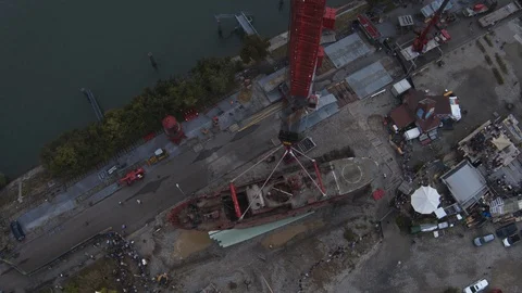 A big red crane preparing an old ship for repairs at the shipyard Stock Footage 120994117