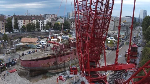 A big red crane preparing an old ship for repairs at the shipyard Stock Footage 120994387