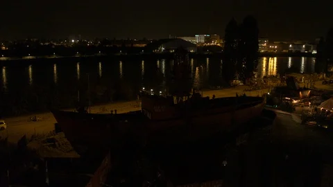 A big red crane preparing an old ship for repairs at the shipyard Stock Footage 120995276