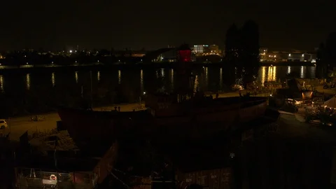 A big red crane preparing an old ship for repairs at the shipyard Stock Footage 120995781