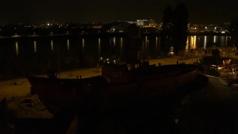 A big red crane preparing an old ship for repairs at the shipyard Stock Footage 120996253