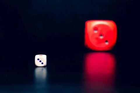Big red dice next to a small white dice Stock Photos