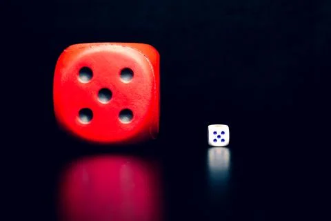 Big red dice next to a small white dice Stock Photos