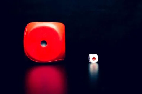 Big red dice next to a small white dice Stock-Fotos