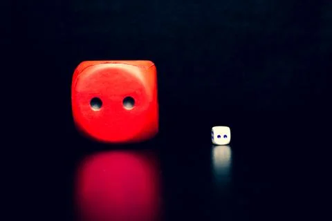 Big red dice next to a small white dice 스톡 사진