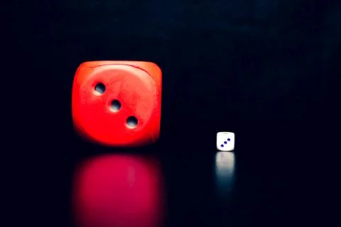 Big red dice next to a small white dice Foto stock